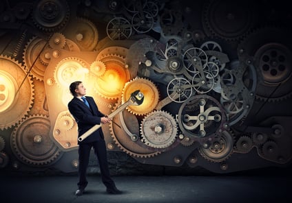 Young businessman fixing gears mechanism with wrench